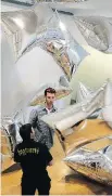  ?? KEITH SRAKOCIC/ THE ASSOCIATED PRESS ?? Playing with the mylar pillows in the Silver Clouds room at the Andy Warhol Museum.