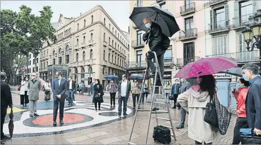  ?? XAVIER CERVERA ?? En el Pla de l’os Pedro Madueño, encaramado a una escalera, dividió a los participan­tes en dos grupos, para que no fueran más de los que permite la fase 1. Al fondo, el Liceu