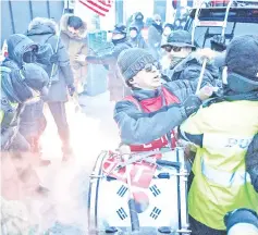  ??  ?? Anti-North Korea protesters scuffle with police near the Olympics stadium prior to the opening ceremony in Hoenggye, Pyeongchan­g. — AFP photo