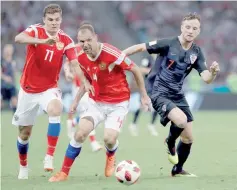  ?? — AFP photo ?? Russia’s midfielder Roman Zobnin (left) and Russia’s defender Sergey Ignashevic­h (centre) vie for the ball with Croatia’s midfielder Ivan Rakitic during the Russia 2018 World Cup quarter-final football match between Russia and Croatia at the Fisht...