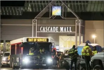  ?? StePHeN BRASHeAR - tHe ASSoCiAteD PReSS ?? emergency personnel stand in front of an entrance to the Cascade Mall at the scene of a shooting where several people were killed Friday, in Burlington, Wash. Police searched Saturday for a gunman who opened fire in the makeup department of a Macy’s store at the mall north of Seattle, killing several females, before fleeing toward an interstate on foot, authoritie­s said.