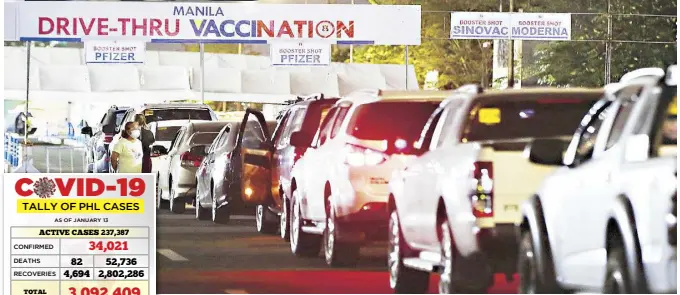  ?? MIGUEL DE GUZMAN ?? Motorists spend the night inside their cars as they queue for booster shots at a drive-through vaccinatio­n area at the Quirino Grandstand in Manila early yesterday.