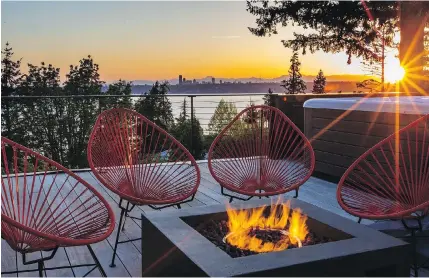  ??  ?? Flames from the gas firepit on the top deck echo the glowing orange sunset behind the Olympic Mountains.