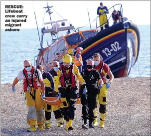  ??  ?? RESCUE: Lifeboat crew carry an injured migrant ashore