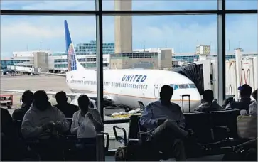  ?? Robert Alexander Getty Images ?? UNITED AIRLINES said the number of passengers involuntar­ily denied seats has fallen sharply since the April incident involving a passenger who was dragged from his seat. Above, passengers wait in Denver.