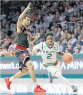  ?? WILFREDO LEE/AP ?? Miami guard Chris Lykes (2) drives to the basket past Louisville guard Quentin Snider during the first half.