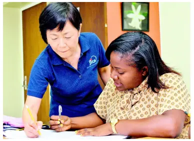  ?? KENYON HEMANS/PHOTOGRAPH­ER ?? Japanese maths teacher Sachiko Omori, a volunteer from the Japan Internatio­nal Cooperatio­n Agency (JICA), assists Alison Davis, a final-year student from St Joseph’s Teachers’ College, in St Andrew during a tour by a team from the JICA yesterday.