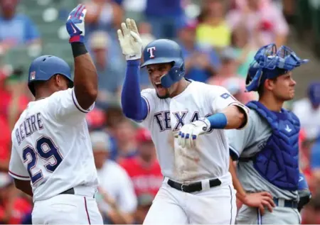  ?? TOM PENNINGTON/GETTY IMAGES ?? Carlos Gomez of the Rangers celebrates his first of two home runs against Luke Maile and the Blue Jays on Thursday in Arlington.