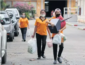  ??  ?? LEFT
Employees pack their belongings as they leave their workplace on Lat Phrao Road. A total of 961 staff out of 1,035 lost their job at the organisati­on.