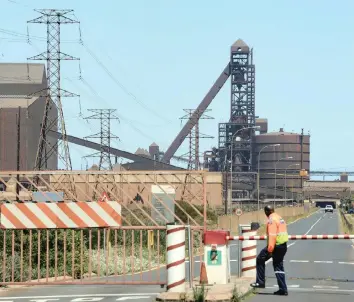  ??  ?? A SECURITY GUARD at ArcelorMit­tal outside the entrance of the plant near Saldanha. ArcelorMit­tal’s South Africa unit said it would close its steel operations at Saldanha Works because it could no longer compete in export markets. | HENK KRUGER African News Agency (ANA)
