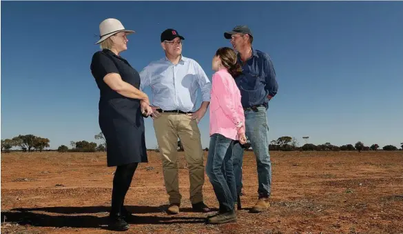  ?? PHOTO: ALEX ELLINGHAUS­EN ?? DROUGHT TOUR: PM Scott Morrison meets with sheep and cattle graziers Annabel and Stephen Tully and their daughter Eve during a visit to their property in Quilpie.