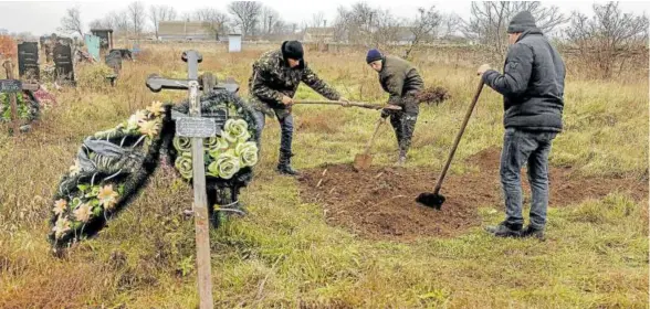  ?? Foto: Efe ?? Residentes ucranianos, apoyados por la policía y expertos forenses, exhuman un cuerpo en la ciudad de Jersón.