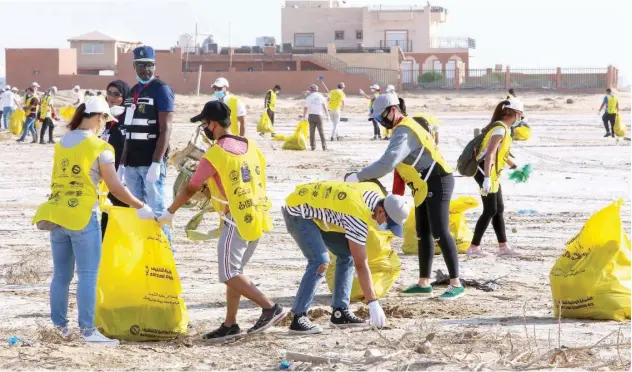  ?? Agence France-presse ?? ↑
Participan­ts clean trash on a beach in Kuwait City on Saturday to coincide with the World Cleanup Day.