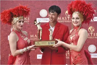  ??  ?? DAVAO-BASED American golfer Micah Lauren Shin receives the trophy after winning the Resorts World Manila Masters last Sunday at the Manila Southwoods Golf and Country Club.