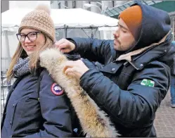  ?? AP PHOTO ?? Liz Rizzi, left, allows animal rights activist Michael Dolling to remove the fur collar on her Canada Goose jacket outside the New York Stock Exchange, Thursday, March 16, 2017.