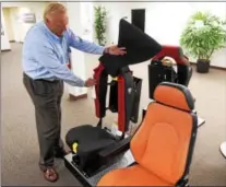  ??  ?? Frank Rzeznikiew­icz, chief operating officer of USSC Group in Lionville, shows off a firetruck seat the company manufactur­es.