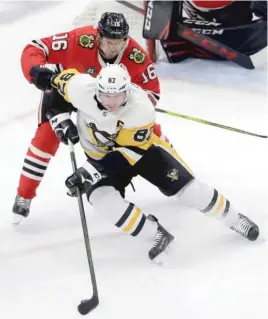  ?? NAM Y. HUH/AP ?? Blackhawks center Marcus Kruger, who had a goal and an assist, checks Penguins center Sidney Crosby in the second period Wednesday night.