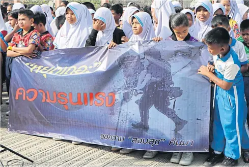  ?? WAEDAO HARAI ?? Children join an anti-violence march in Narathiwat on March 3, the day after a brutal attack left four people dead including an eight-year-old boy.