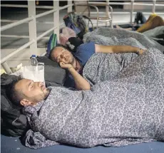  ??  ?? Mohammed al-Haj, foreground, and his friend Dr. Mohanad AbdulQader, also from Syria, sleep on the deck of a ferry in this photo taken on Wednesday, Sept. 9, 2015, as they travel from Lesbos to Athens.