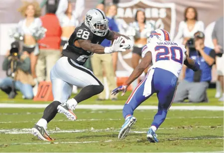  ?? DAN HONDA/STAFF PHOTOS ?? The Raiders’ Latavius Murray (28) tries to elude the Buffalo Bills’ Corey Graham (20) in the first half of Sunday’s game at the Coliseum.