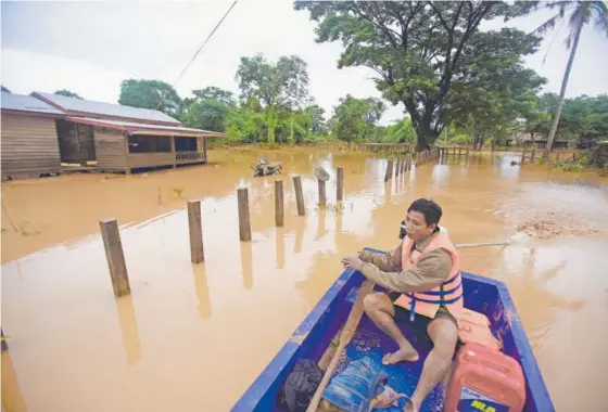  ?? AFP ?? Varias personas regresaron ayer a sus hogares afectados por las inundacion­es en la aldea de Sanamxai, en la provincia de Attapeu, en Laos.