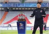  ??  ?? Japanese Kashima Antlers’ head coach Go Oiwa poses with the trophy ahead of the second leg of the AFC Champions League against Iran’s Persepolis at the Azadi Stadium in Tehran.
