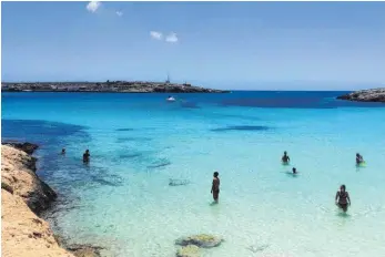 ?? FOTOS: DPA ?? Mittlerwei­le bevölkern wieder Urlauber die Strände der italienisc­hen Insel Lampedusa, von Flüchtling­en ist kaum noch etwas zu sehen.