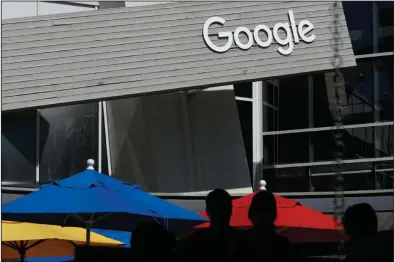  ?? (AP) ?? People walk by a Google sign on the company’s campus in Mountain View, Calif. Google is among companies delaying sending workers back to the office.