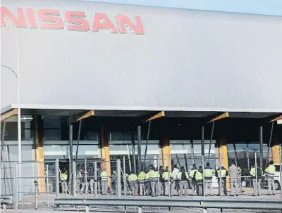  ?? Quique García / EFE ?? Treballado­rs de Nissan recollint la carta d’acomiadame­nt fa un any