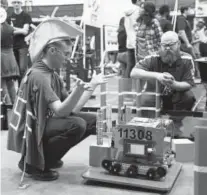  ?? Andy Cross, The Denver Post ?? Steve Wingate, a member of Legend High School’s team WISE, helps tune up its robot, Einstein, in a practice area during the FIRST Tech Challenge robotics competitio­n on Saturday.