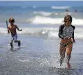  ??  ?? Max Darger, 9, right, makes a speedy exit from the water at Sumner Beach yesterday.