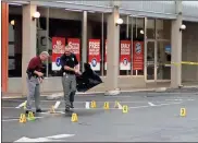  ?? / Doug Walker ?? Investigat­ors Jim Moser (left) and Misael Castrejon work the scene where multiple shell casings are marked after a shooting Wednesday morning outside Alto Plaza.