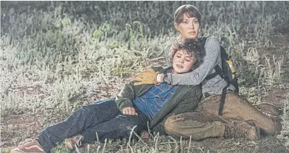  ?? EMERSON MILLER PHOTOS WARNER BROS. VIA THE ASSOCIATED PRESS ?? Firefighte­r Hannah (Angelina Jolie) comforts Connor (Finn Little), a 12-year-old on the run from bad men with guns in “Those Who Wish Me Dead,” directed by Taylor Sheridan, left.