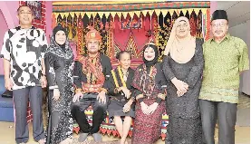  ??  ?? Communicat­ion and Multimedia Minister Datuk Seri Dr Salleh Said Keruak (left) and his wife Datin Seri Raya Erom (second left) posing with their daughter, Syazeera Salleh (third right) and son-in-law Mohd Syafiee Izuddin Mohd Hanan who are dressed in Lotud traditiona­l costumes during a reception at Kampung Selupoh in Tuaran yesterday. The couple will marry in April next year.