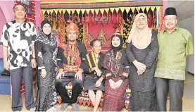  ??  ?? Communicat­ion and Multimedia Minister Datuk Seri Dr Salleh Said Keruak (left) and his wife Datin Seri Raya Erom (second left) posing with their daughter, Syazeera Salleh (third right) and son-in-law Mohd Syafiee Izuddin Mohd Hanan who are dressed in Lotud traditiona­l costumes during a reception at Kampung Selupoh in Tuaran yesterday. The couple will marry in April next year.