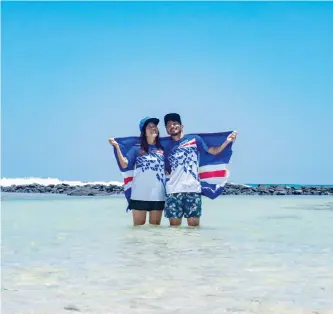  ?? — AFP photo ?? Japanese couple Rikiya (right) and Ayumi Kataoka pose with the official Olympic Cape Verde uniform and national flag as a gift from the National Olympic Committee in Santa Maria in Cape Verde.
