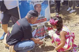  ?? JOHN UNSON ?? Relatives of a victim of the Maguindana­o massacre light candles at a shrine in Barangay Masalay in Ampatuan town, Maguindana­o yesterday, the 8th anniversar­y of the attack which killed 58 persons, including 32 media workers.