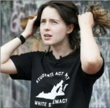  ?? STEVE HELBER — THE ASSOCIATED PRESS ?? University of Virginia graduate Claire Carlson fixes her hair during an interview in the downtown area of Charlottes­ville, Va., Saturday. She was involved in last year’s torch lit white supremacis­t rally at the school.