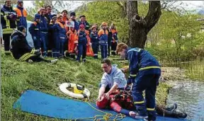  ??  ?? Immer wieder musste Gabi Gräfe aus dem See gerettet werden. Fabian Schlufter (Drk-wasserwach­t) und Vincent Becker von der Thw-jugendgrup­pe zeigen die stabile Seitenlage.