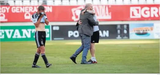  ?? E.S. ?? Pandalone se abraza con un miembro del cuerpo técnico mientras Ismael Chico llora tras la permanenci­a en Murcia de 2018.