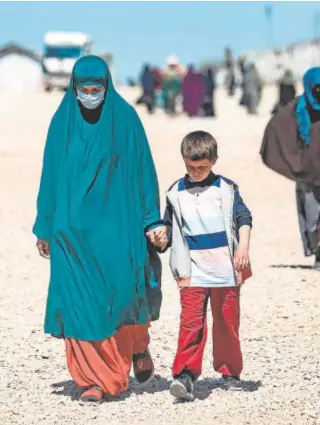  ?? // AFP ?? Una mujer y un niño caminan por el campo de refugiados de Al Roj