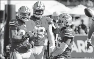  ?? JOHN LOCHER/AP ?? Solomon Thomas, left, celebrates with teammates after a sack during the 49ers’ victory Sunday.