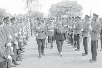  ?? AP ?? Madam president: Samia Suluhu Hassan, center-right, inspects the guard of honor after being sworn in Friday as Tanzania’s new president in a ceremony in Dar es Salaam, Tanzania. The former vice president made history as the East African country’s first female president, following the death of predecesso­r John Magufuli on Wednesday. He was 61.