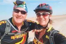  ??  ?? ■ Susan Besterwith her husband Deon. They are used to seeing camels on their desert cycling trips every weekend.