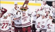  ?? Keith Srakocic / Associated Press ?? UMass’ George Mika (29) holds the NCAA trophy as he skates with the team to celebrate their 5-0 win over St. Cloud State in the Frozen Four title game Saturday.