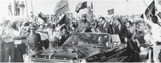  ??  ?? In this Nov 10, 1971 file photo, Castro (center left) rides with Chile’s President Salvador Allende through a crowd waving communist flags in Santiago, Chile.