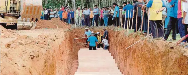  ?? FILE
PIC ?? Villagers helping to bury some of the bodies of the human traffickin­g victims in Wang Kelian, Perlis in June this year.