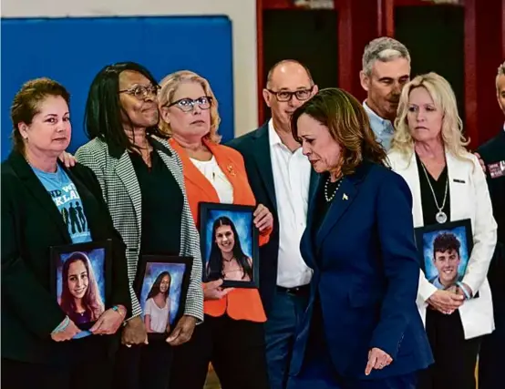  ?? DREW ANGERER/AFP VIA GETTY IMAGES ?? Relatives held portraits of Marjory Stoneman Douglas High School shooting victims as Vice President Kamala Harris looked on.