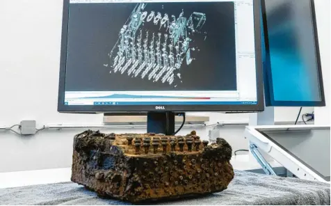  ?? Foto: Axel Heimken, dpa ?? Eine Enigma  Verschlüss­elungsmasc­hine liegt vor dem Monitor eines Computerto­mografen aus der Medizintec­hnik, mit dem eine 3D  Ansicht des rätselhaft­en Geräts aus dem Zweiten Weltkrieg erzeugt wurde.