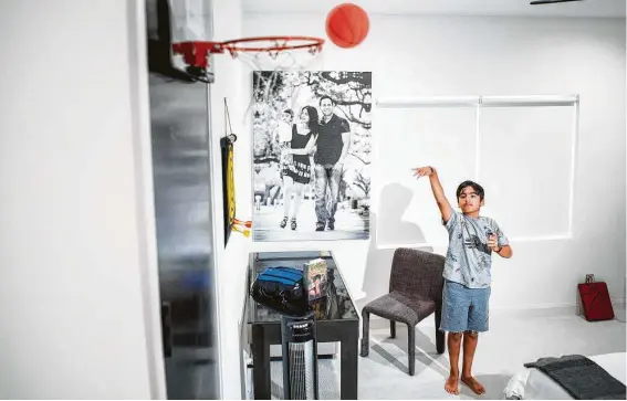  ?? Photos by Mark Mulligan / Staff photograph­er ?? Aryan Magon shoots a foam basketball in his bedroom, where his parents bought him a new desk so he can do schoolwork in a quieter environmen­t.